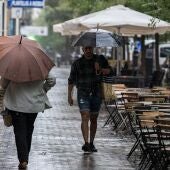 Varias personas se resguardan de la lluvia en plena DANA