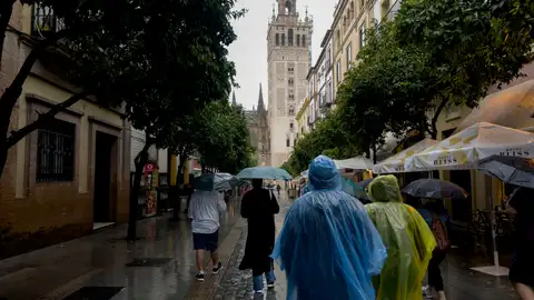 Personas protegiéndose de la lluvia La Aemet quita los avisos en todas las comunidades, salvo en Galicia, tras el paso de la DANA