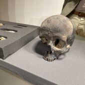 Un cráneo negro, cubierto en óxido de manganeso, y una muestra de objetos encontrados en el interior de La Garma