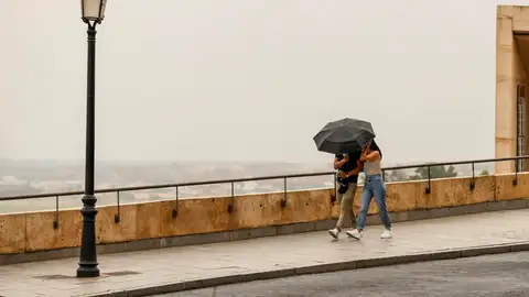 Una pareja se protege de la lluvia en Toledo. Una pareja se protege de la lluvia en Toledo.