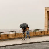 Una pareja se protege de la lluvia en Toledo.