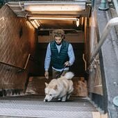 Imagen de archivo de un hombre saliendo del metro con su perro