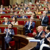 El presidente de la Generalitat, Pere Aragonès (i), junto a los diputados de los partidos independentistas aplauden el resultado de la votación durante el pleno del Parlament. 