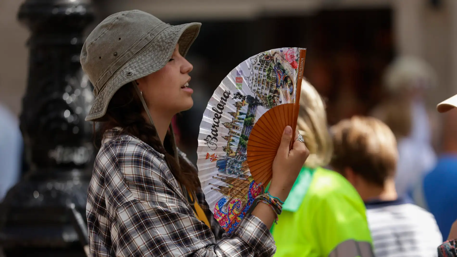 Una turista intenta refrescarse con un abanico en el centro de Barcelona