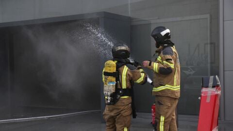 Imagen de archivo de varios bomberos trabajan en las labores de extinción de un incendio en Vigo