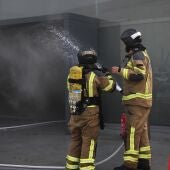 Imagen de archivo de varios bomberos trabajan en las labores de extinción de un incendio en Vigo