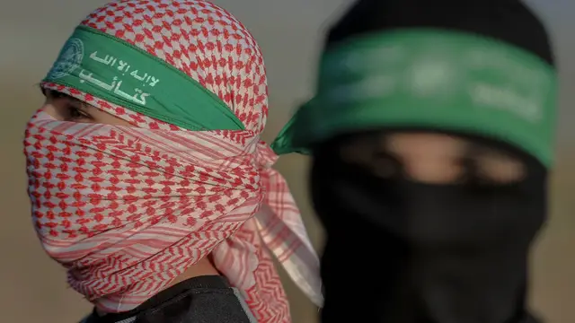 Dos hombres portando la banda distintiva de las milicias de Hamás