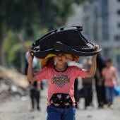Un chico lleva un carrito para bebés en la evacuación de Gaza tras el ultimatum israelí. 