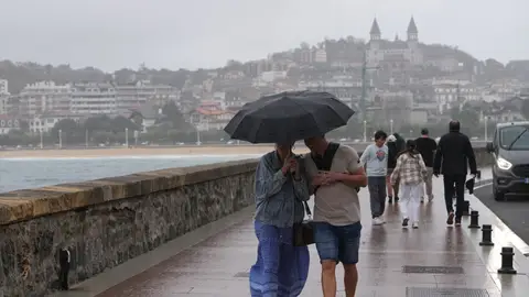 Dos personas pasean bajo la lluvia en San Sebastián El tren de borrascas continúa este lunes con fuertes lluvias y tormentas