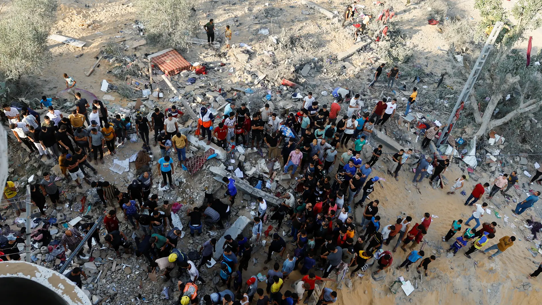 Los palestinos junto a los escombros tras los ataques israelíes en Khan Younis, al sur de Gaza