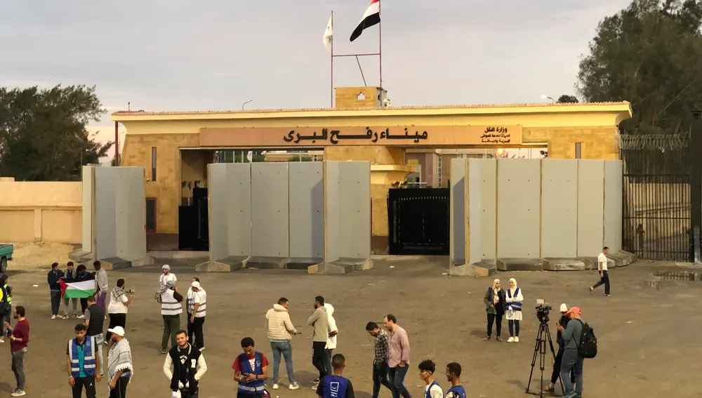 Voluntarios de organizaciones humanitarias esperan fuera de la puerta fronteriza de Rafah, Egipto
