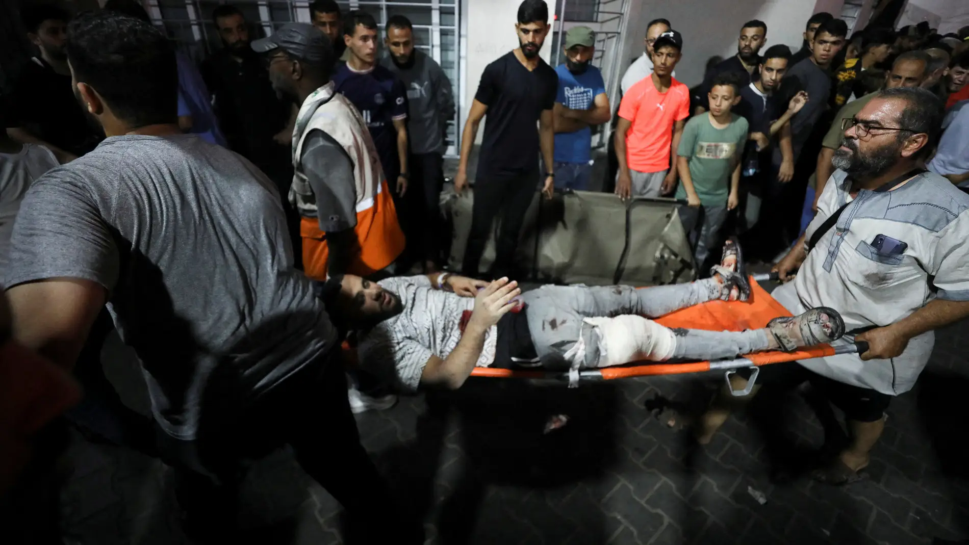 Operarios evacúan a uno de los heridos tras el bombardeo en un hospital de Gaza.