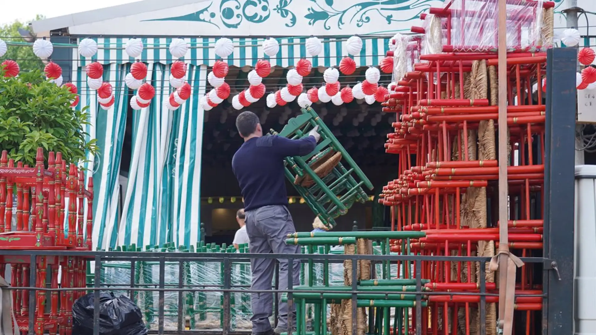Trabajadores preparan y adecentan una de las casetas del recinto de la Feria de Abril de Sevilla