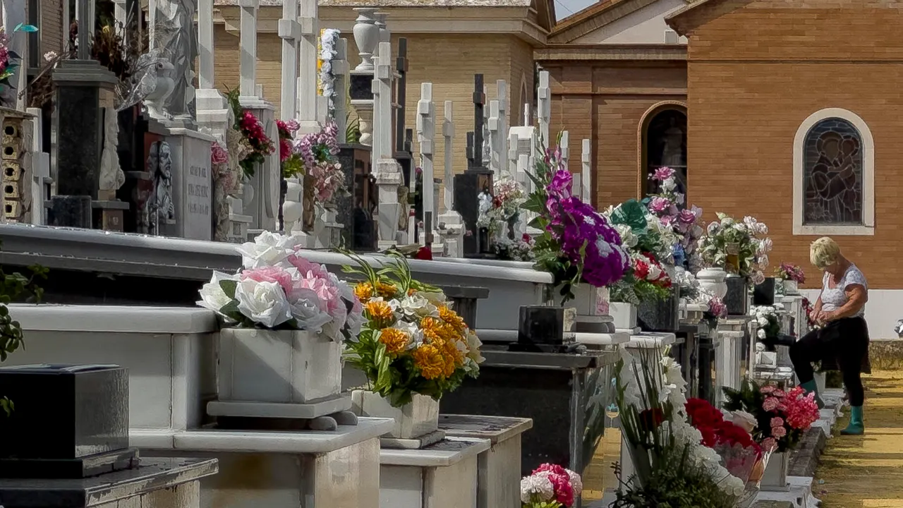 Personas limpian y colocan flores como preparativo del Día de Todos los Santos