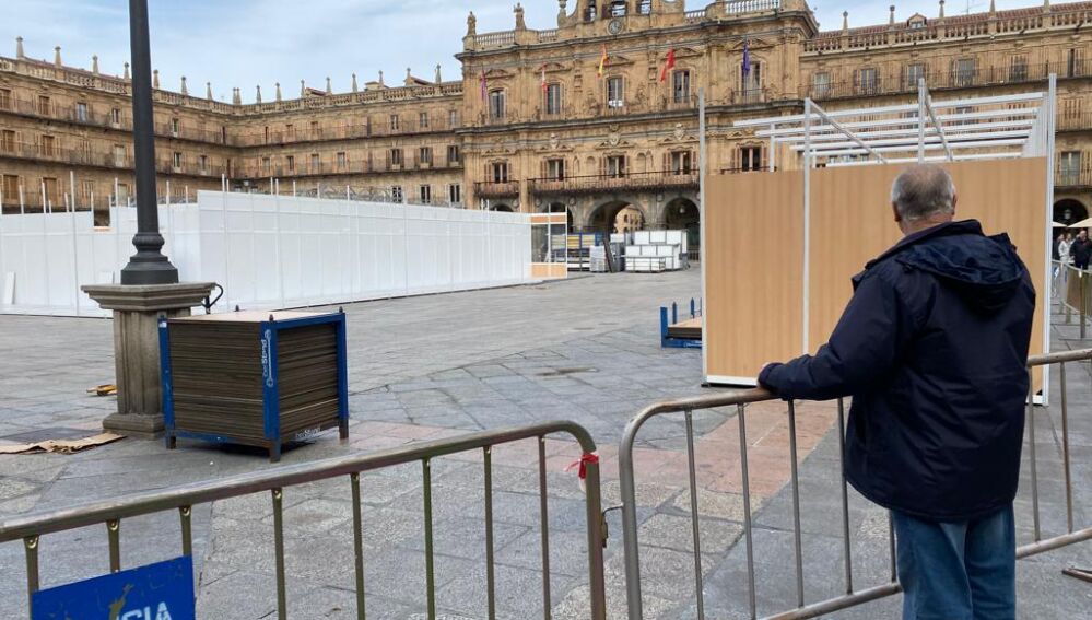 Curioso divisando el montaje de los puestos en la Plaza Mayor de Salamanca