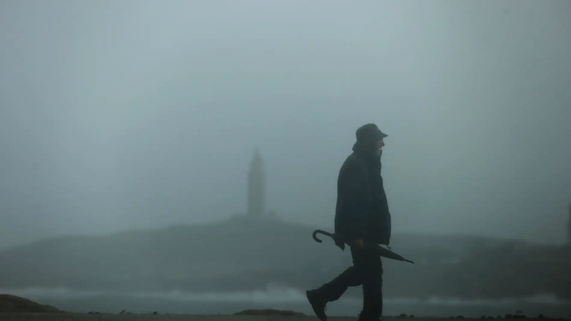 Un hombre camina por el paseo marítimo de A Coruña
