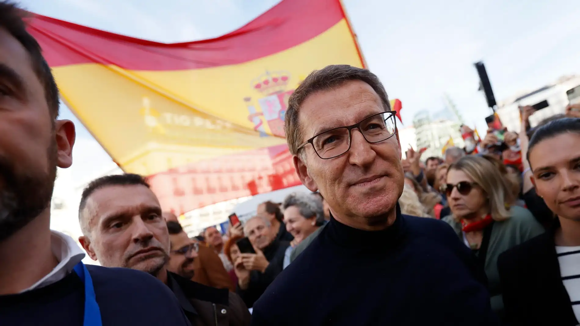 El líder del PP Alberto Núñez Feijóo con una bandera de España de fondo