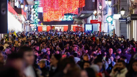 Cientos de personas pasean este martes por el centro de Madrid iluminado con motivo de las fiestas navideñas.