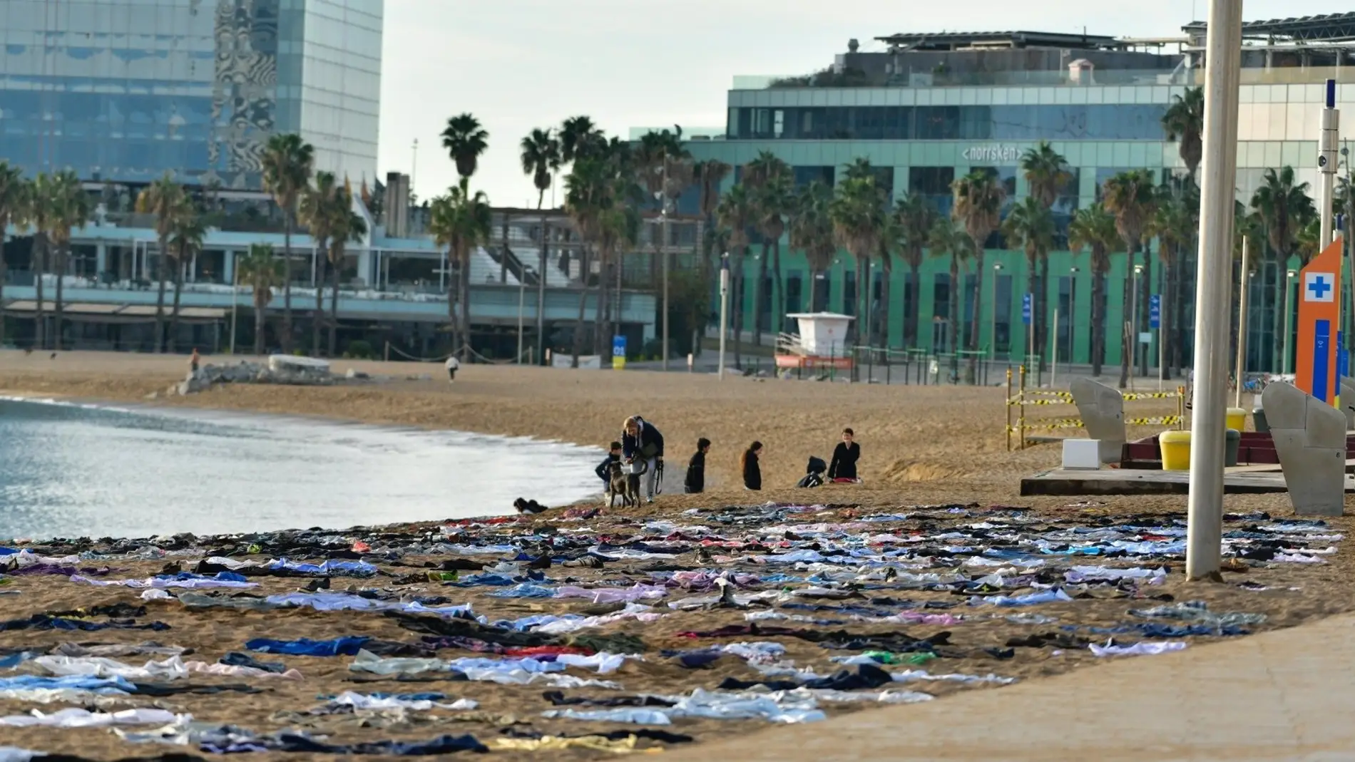 Open Arms escenifica un naufragio en la playa de Barcelona para denunciar más de 2.600 muertes este año en el Mar Mediterráneo