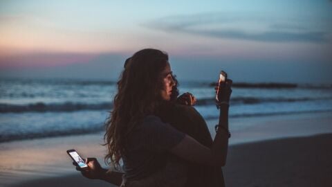 Una pareja consultando el tel&eacute;fono m&oacute;vil 