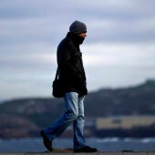 Imagen de una persona paseando abrigada para protegerse del frío