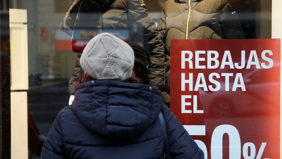Una persona observa el escaparate de una tienda con rebajas