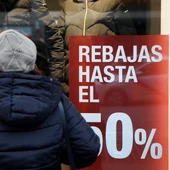 Una persona observa el escaparate de una tienda con rebajas Una persona observa el escaparate de una tienda con rebajas