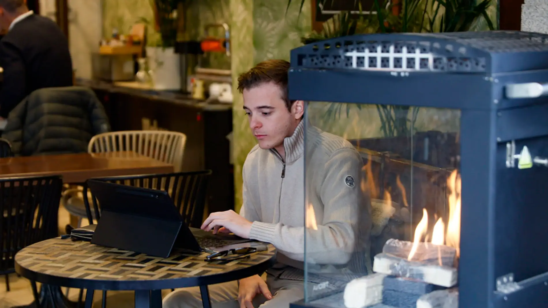  Un hombre utiliza un ordenador al lado de una chimenea en una cafetería este martes en Madrid/ EFE/Mariscal