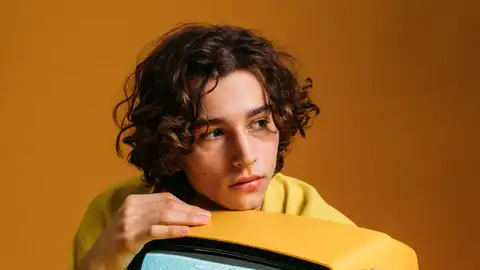 Un joven sobre una televisión Un joven sobre una televisión