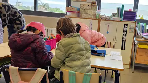 Los alumnos con gorro, abrigo y guantes Los alumnos con gorro, abrigo y guantes