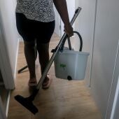 Imagen de archivo de una empleada de hogar con herramientas de limpieza.