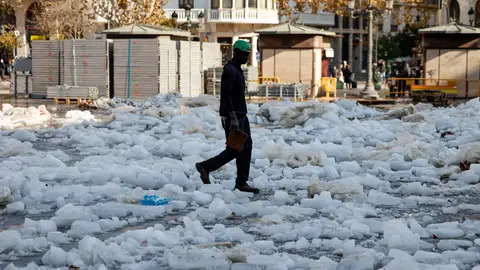 Un operario trabaja en el desmontaje de la pista de hielo en la plaza del Ayuntamiento de Valencia durante la mañana del viernes tras una noche fría, con heladas en el interior. Un frente asociado a la borrasca Hipólito provocará un aumento de temperaturas y lluvias