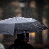 Una mujer camina bajo su paraguas en San Sebastián