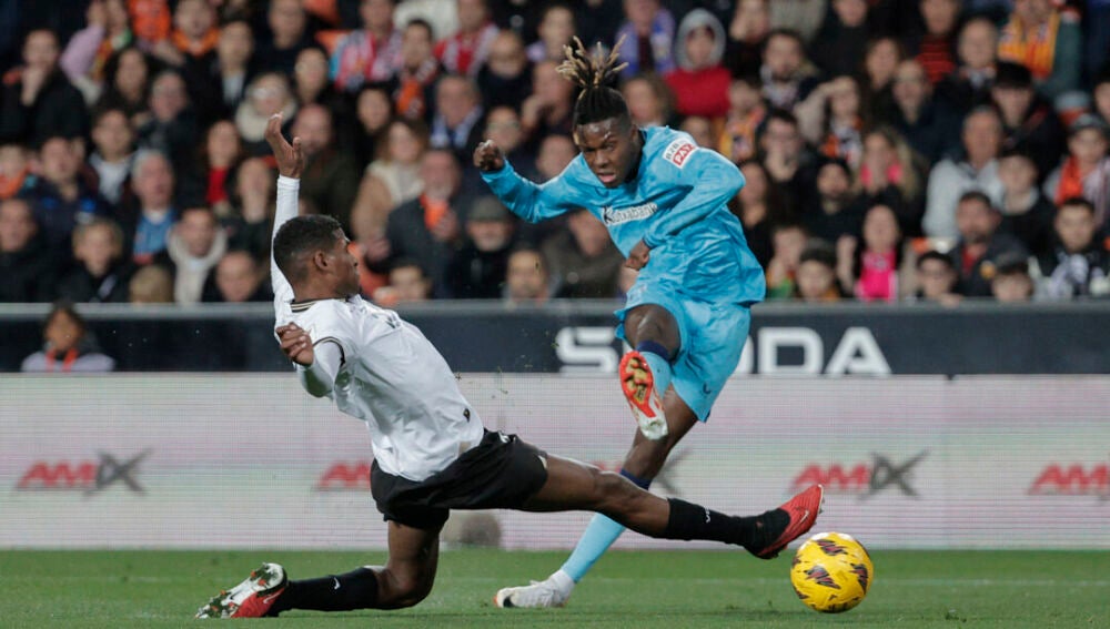  El delantero del Athletic Club, Nico Williams, remata ante el defensa del Valencia, Cristhian Mosquera