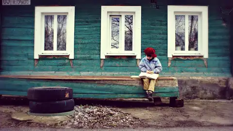 Imagen de archivo de un niño sólo frente a una casa en el campo Un niño de nueve años sobrevivió durante dos años solo en casa sin agua caliente ni electricidad