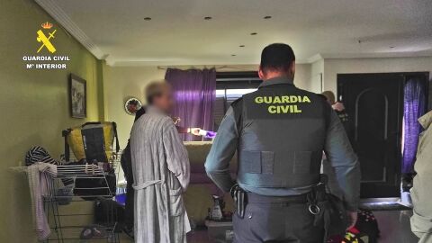 Un agente vigila a uno de los arrestados