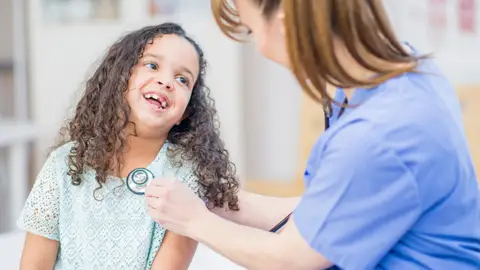 Niña atendida por enfermera Niña atendida por enfermera