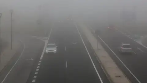 Coche en una carretera con niebla Coche en una carretera con niebla