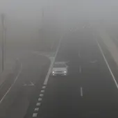 Coche en una carretera con niebla Coche en una carretera con niebla