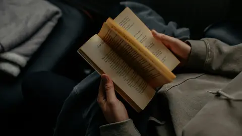 Imagen de archivo de una persona leyendo un libro. Imagen de archivo de una persona leyendo un libro.