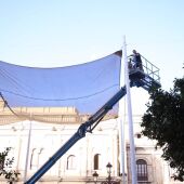 Operario trabajando en el desmontaje de los toldos en la Plaza de San Francisco de Sevilla