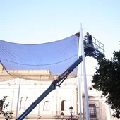 Operario trabajando en el desmontaje de los toldos en la Plaza de San Francisco de Sevilla Operario trabajando en el desmontaje de los toldos en la Plaza de San Francisco de Sevilla