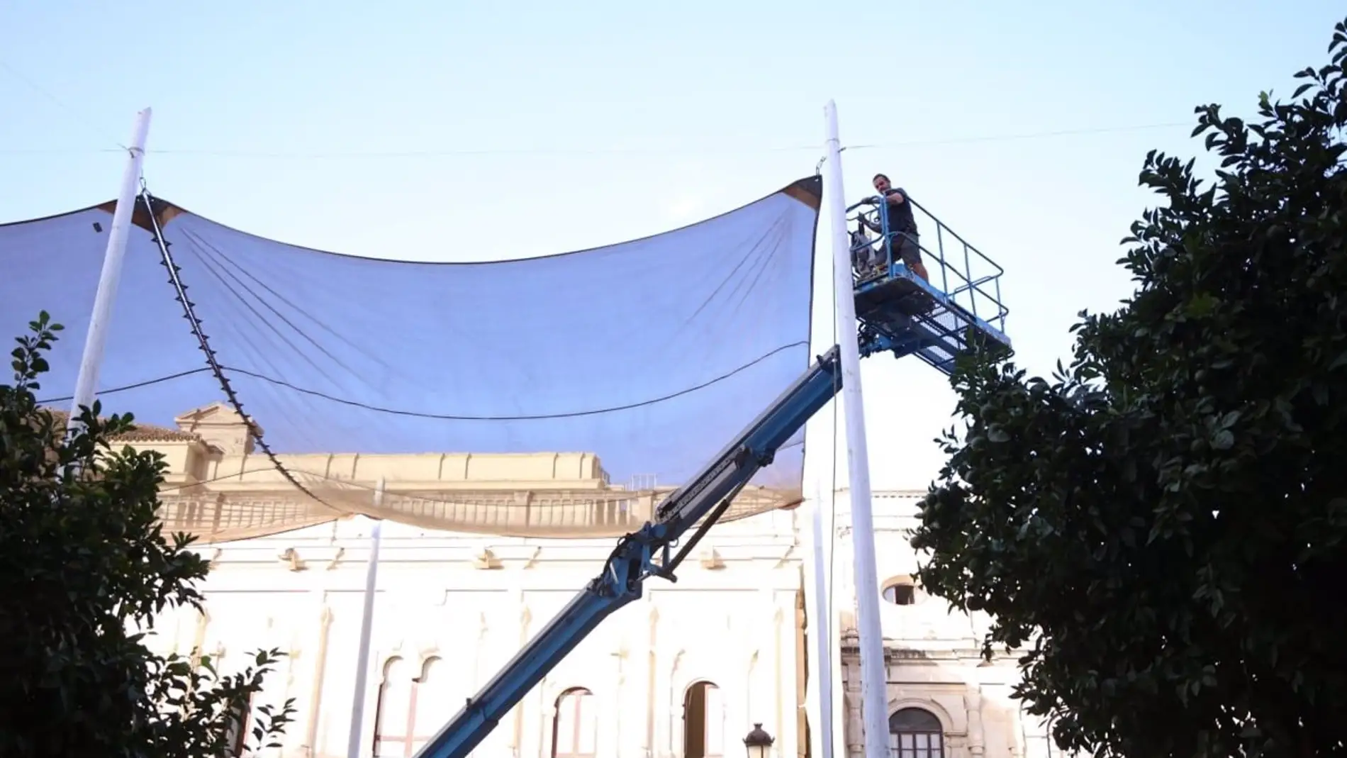 Operario trabajando en el desmontaje de los toldos en la Plaza de San Francisco de Sevilla