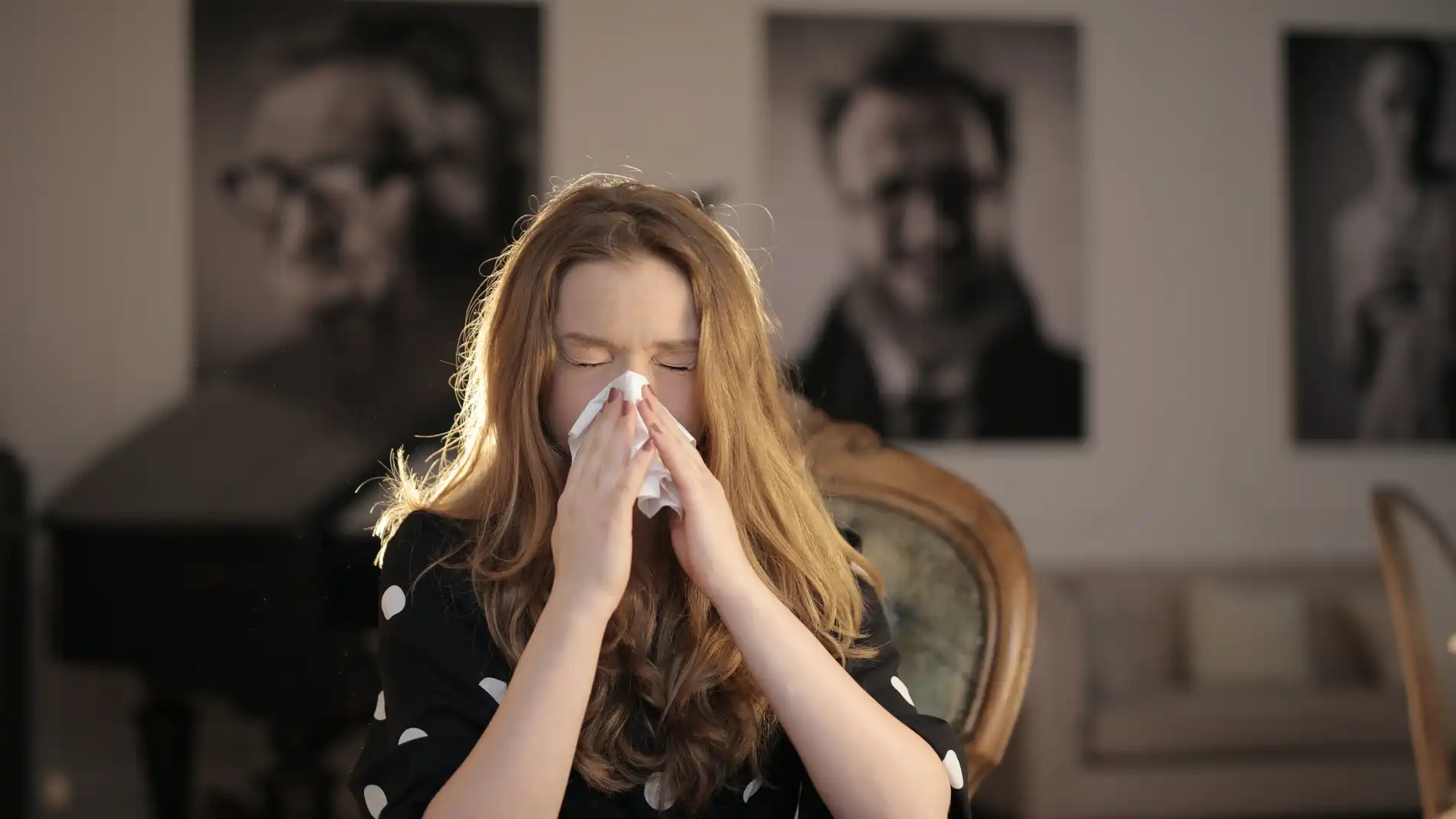 Imagen de archivo de una mujer que estornuda.