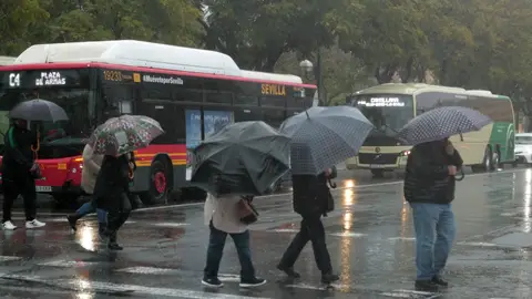 Imagen de varias personas bajo la lluvia en Sevilla durante el paso de la borrasca 'Karlotta' Vuelve el frío: 'Karlotta' deja un fin de semana invernal con lluvia, viento y nieve