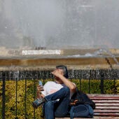 Una persona aguarda sentada al sol en el centro de la ciudad cuando el cielo de la Comunitat Valenciana