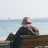 Imagen de archivo de un anciano leyendo frente al mar
