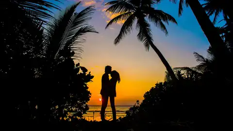 Una pareja besándose al atardecer Una pareja besándose al atardecer