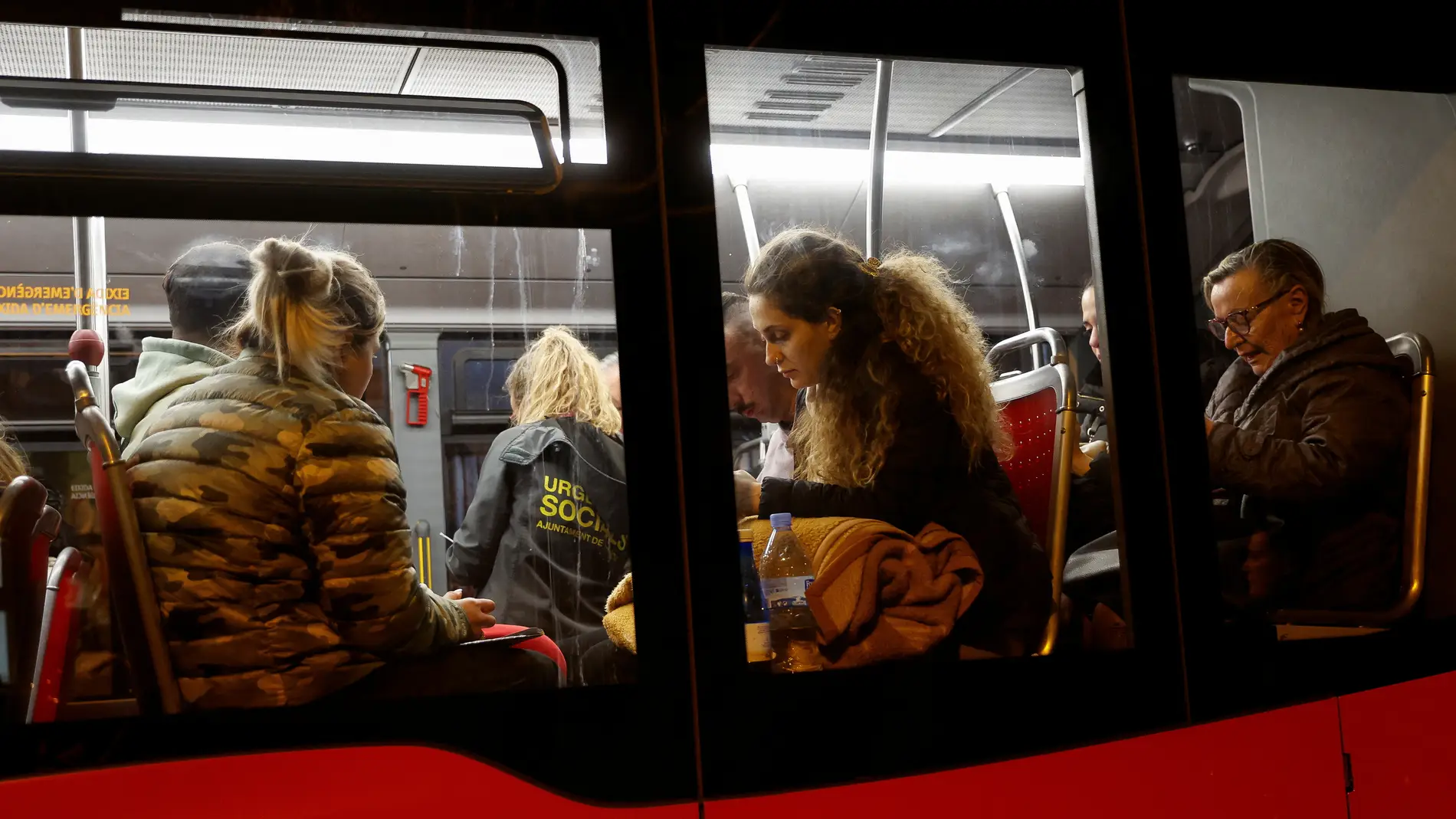 Residentes evacuados del edificio incendiado en Valencia en un autobús cercano al lugar del fuego.