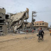  La gente pasa junto a edificios destruidos en los ataques israelíes en la ciudad de Khan Younis, en el sur de la Franja de Gaza